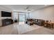 A well-lit living room with a sectional sofa, a fireplace, and a sliding glass door at 6790 Tangled Vines Ave, Las Vegas, NV 89139