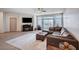 A comfortable living room with a sectional sofa, a fireplace, and plenty of natural light at 6790 Tangled Vines Ave, Las Vegas, NV 89139