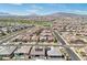 Vast aerial view of a Primary-planned community with green spaces, neighborhood streets, and mountain views at 716 Cadence View Way, Henderson, NV 89011