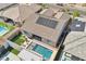 Aerial view of a home with a pool, artificial turf, and solar panels on the roof at 716 Cadence View Way, Henderson, NV 89011