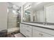 Bathroom with double sink vanity, framed mirrors, walk-in shower with glass enclosure, and tile surround at 716 Cadence View Way, Henderson, NV 89011