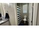 This bathroom features a toilet, vanity, shower with striped curtain and a neutral color scheme at 716 Cadence View Way, Henderson, NV 89011