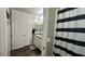 Well lit bathroom with shower with a striped curtain, gray counters, and wood-look flooring at 716 Cadence View Way, Henderson, NV 89011