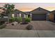 Charming single-story home featuring desert landscaping and a paved driveway leading to a two-car garage at 716 Cadence View Way, Henderson, NV 89011