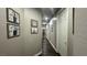 Well-lit hallway with wood floors, adorned with Gathering photos, leading to other rooms at 716 Cadence View Way, Henderson, NV 89011