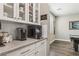 Kitchenette area with a coffee bar, glass display cabinets, and a view leading into the game room at 716 Cadence View Way, Henderson, NV 89011