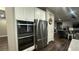 Well-equipped kitchen with built-in oven, stainless steel refrigerator, and adjacent living space at 716 Cadence View Way, Henderson, NV 89011