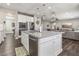 Open-concept kitchen featuring white cabinets, stainless steel appliances, an island, and views into the living room at 716 Cadence View Way, Henderson, NV 89011