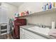 This laundry room features a sink, counter space, white cabinets, and a modern red washer and dryer set at 716 Cadence View Way, Henderson, NV 89011
