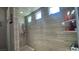 Modern shower with tile surround, built-in shelving, and natural light at 716 Cadence View Way, Henderson, NV 89011