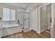 Bright bathroom with a large tub, glass shower, and wood-look tile floors at 741 Monroe Hill Pl, Henderson, NV 89011
