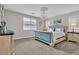 Sophisticated bedroom with plush carpet, chandelier, and serene natural light at 741 Monroe Hill Pl, Henderson, NV 89011
