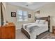 Bright bedroom with a wooden frame bed, neutral carpet, and sunlit window views at 741 Monroe Hill Pl, Henderson, NV 89011