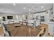 Open concept dining room showcasing kitchen with large island, pendant lights, wood floors, and view of living room at 741 Monroe Hill Pl, Henderson, NV 89011