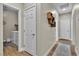 Hallway with access to the laundry room and a decorative wood shelf creating a functional and stylish space at 741 Monroe Hill Pl, Henderson, NV 89011