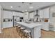 Bright kitchen features white cabinets, stainless steel appliances, an island with bar stool seating, and pendant lighting at 741 Monroe Hill Pl, Henderson, NV 89011