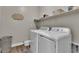 Efficient laundry room with a washer, dryer, and overhead shelving for convenient storage and organization at 741 Monroe Hill Pl, Henderson, NV 89011