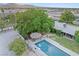 Lush backyard oasis with a shimmering swimming pool, charming tiki hut, and mature trees against a backdrop of city views at 7545 Constantinople Ave, Las Vegas, NV 89129