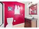 Eclectic bathroom with a red accent wall, toilet and vanity at 7545 Constantinople Ave, Las Vegas, NV 89129