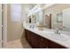 Clean bathroom featuring double sinks, cherry wood cabinets, and a large mirror at 7567 Desertscape Ave, Las Vegas, NV 89178