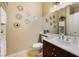 Bathroom with a single sink, cherry wood cabinets, and decorative mirror accents at 7567 Desertscape Ave, Las Vegas, NV 89178