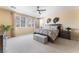 Bright bedroom featuring a ceiling fan, large windows, and a comfortable-looking bed at 7567 Desertscape Ave, Las Vegas, NV 89178