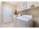 Well-lit laundry room with a washer, dryer, sink, shelving and tile floors at 7567 Desertscape Ave, Las Vegas, NV 89178
