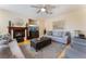 Cozy living room with a fireplace, plush seating, and a ceiling fan for year-round comfort at 7567 Desertscape Ave, Las Vegas, NV 89178