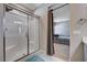 Bright bathroom showcasing a tiled shower with sliding glass door and marble flooring at 7572 Mount Spokane Ct, Las Vegas, NV 89113