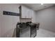 Modern laundry room with upper cabinets and new washer and dryer units at 7572 Mount Spokane Ct, Las Vegas, NV 89113