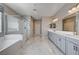 Main bathroom featuring double vanity, soaking tub, and glass-enclosed shower at 7572 Mount Spokane Ct, Las Vegas, NV 89113