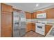 Modern kitchen with stainless steel appliances and wood cabinets, plus a stacked washer/dryer at 7632 Calico Fields St, Las Vegas, NV 89149