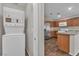 Modern kitchen with stainless steel appliances and wood cabinets, plus a stacked washer/dryer at 7632 Calico Fields St, Las Vegas, NV 89149