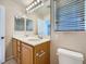 Well-lit bathroom with double sinks, a large mirror, wood cabinets and tile flooring at 765 Jewel Tower St, Las Vegas, NV 89178