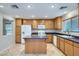 Bright kitchen featuring wood cabinets, a kitchen island, white appliances, and tiled flooring at 765 Jewel Tower St, Las Vegas, NV 89178