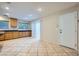 Open kitchen with a patio door and access to the backyard, featuring wood cabinets and tiled flooring at 765 Jewel Tower St, Las Vegas, NV 89178