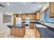 Sunlit kitchen with wood cabinets, a kitchen island, and a white ceramic sink at 765 Jewel Tower St, Las Vegas, NV 89178