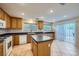 Well-lit kitchen with a kitchen island, stainless steel sink, white appliances, and a tiled floor at 765 Jewel Tower St, Las Vegas, NV 89178