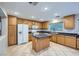 Traditional kitchen with wood cabinets, kitchen island, white appliances, and tiled flooring at 765 Jewel Tower St, Las Vegas, NV 89178