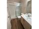 Bathroom features a shower over bath with glass doors and a vanity with a sink at 7969 Cina Ave, Las Vegas, NV 89147