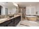 Bathroom featuring a double vanity, stone shower, and tub at 8 Laricola Ct, Henderson, NV 89011