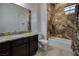 Elegant bathroom with marble-style shower, bathtub, granite countertops, and dark wood cabinets at 8 Laricola Ct, Henderson, NV 89011
