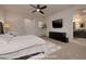 Staged bedroom with a ceiling fan, mounted television, and ensuite bathroom at 8 Laricola Ct, Henderson, NV 89011
