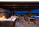 Outdoor patio featuring fireplace, outdoor dining area, and lounge seating at night at 8 Laricola Ct, Henderson, NV 89011