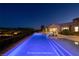 Infinity pool and hot tub at night with city lights and mountain views in the background at 8 Laricola Ct, Henderson, NV 89011