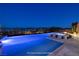 Infinity pool and hot tub at night with city lights and mountain views in the background at 8 Laricola Ct, Henderson, NV 89011