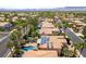 Serene aerial view of a neighborhood with lush greenery, sparkling pools, and solar panels at 8205 Taos Paseo Ave, Las Vegas, NV 89128