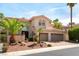 Elegant two-story home with a three-car garage and desert landscaping featuring palm trees at 8205 Taos Paseo Ave, Las Vegas, NV 89128