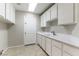 Well-lit laundry room featuring white cabinetry, sink, and tile floors at 8205 Taos Paseo Ave, Las Vegas, NV 89128