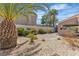 Beautiful backyard featuring desert landscaping, gravel, palm trees, and a charming covered patio area at 8437 Apple Hill Ct, Las Vegas, NV 89128